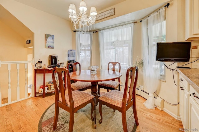 dining area with a baseboard heating unit, a notable chandelier, and light wood-type flooring