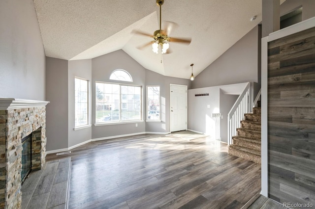 unfurnished living room with a textured ceiling, dark hardwood / wood-style floors, ceiling fan, and a fireplace