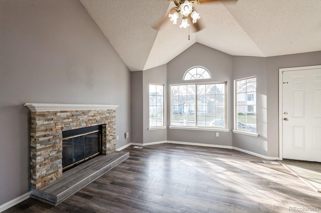 unfurnished living room with lofted ceiling, dark wood-type flooring, ceiling fan, a fireplace, and a textured ceiling