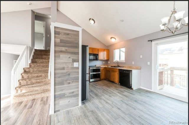 kitchen featuring an inviting chandelier, black appliances, sink, hanging light fixtures, and light wood-type flooring