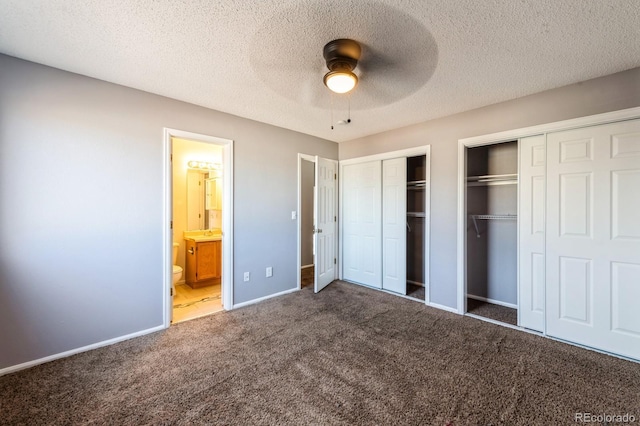 unfurnished bedroom featuring dark colored carpet, ceiling fan, a textured ceiling, and connected bathroom