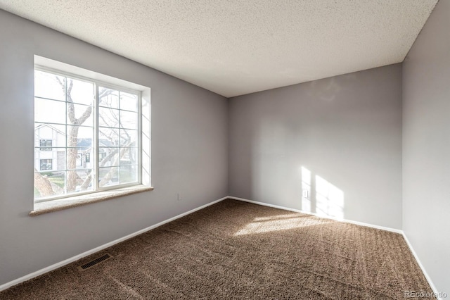 carpeted empty room with a textured ceiling