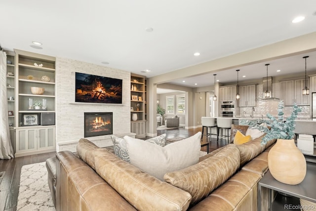 237 Maplehurst Dr, Highlands Ranch, CO 80126 - living area with wood finished floors, recessed lighting, a large fireplace, and built in shelves