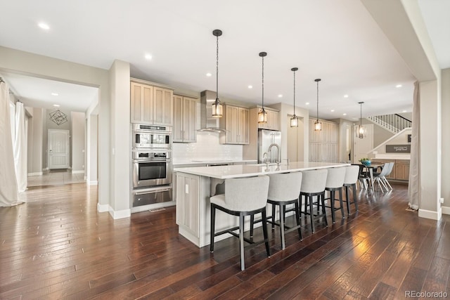 237 Maplehurst Dr, Highlands Ranch, CO 80126 - kitchen featuring wall chimney exhaust hood, stainless steel appliances, a warming drawer, a large island with sink, and light countertops