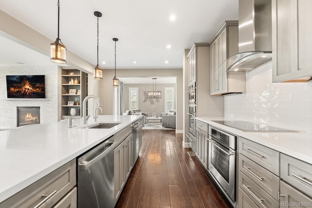 237 Maplehurst Dr, Highlands Ranch, CO 80126 - kitchen featuring gray cabinetry, stainless steel appliances, open floor plan, wall chimney exhaust hood, and a sink