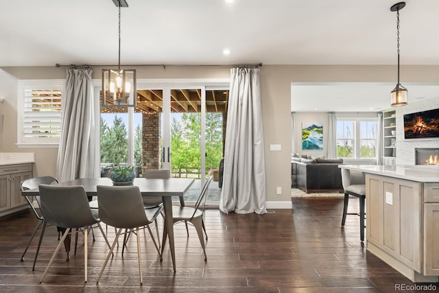 237 Maplehurst Dr, Highlands Ranch, CO 80126 - dining space featuring a glass covered fireplace, dark wood-type flooring, recessed lighting, a chandelier, and baseboards