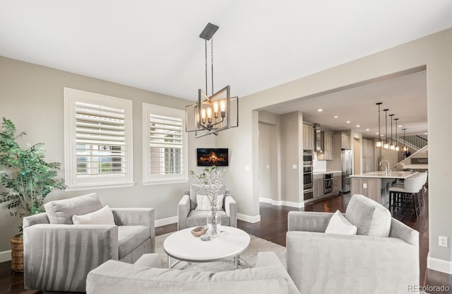 237 Maplehurst Dr, Highlands Ranch, CO 80126 - living area with a chandelier, baseboards, dark wood-type flooring, and recessed lighting