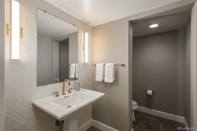 237 Maplehurst Dr, Highlands Ranch, CO 80126 - half bathroom featuring toilet, baseboards, tile patterned flooring, and a sink
