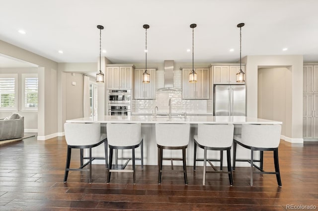 237 Maplehurst Dr, Highlands Ranch, CO 80126 - kitchen with wall chimney range hood, appliances with stainless steel finishes, a large island, baseboards, and a breakfast bar area