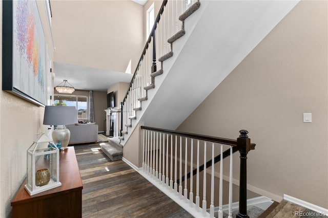 stairs featuring wood finished floors and baseboards