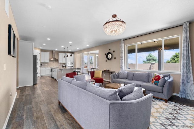 living room featuring dark wood finished floors, recessed lighting, baseboards, and a chandelier
