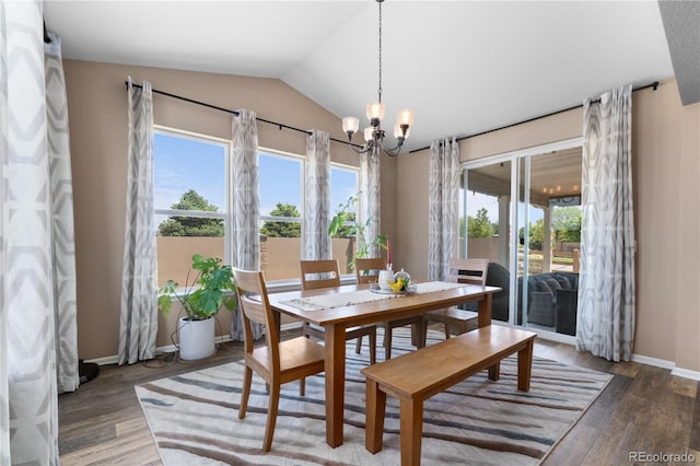 dining room featuring a chandelier, lofted ceiling, wood finished floors, and baseboards