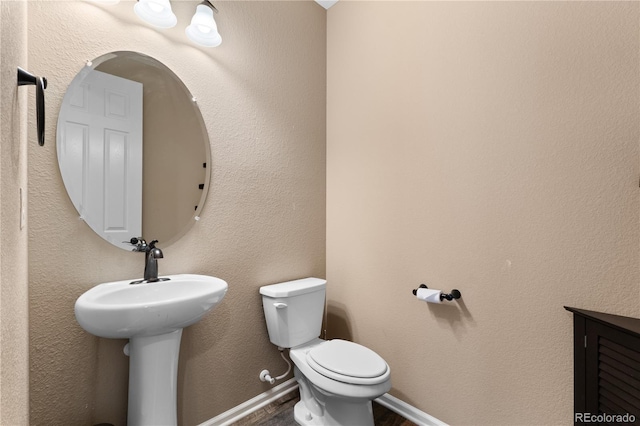 half bath featuring toilet and wood finished floors