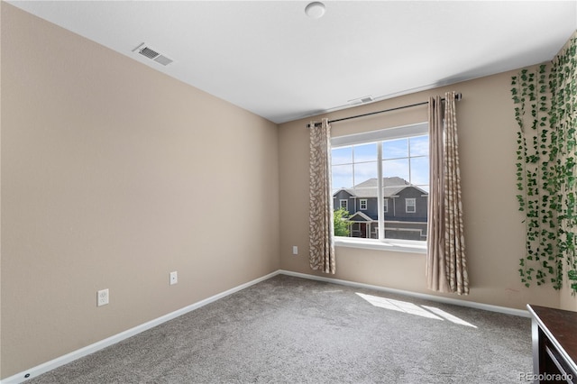 carpeted spare room featuring baseboards