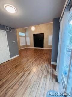 6973 Summerset Ave, Longmont, CO 80504 - unfurnished living room featuring baseboards and wood finished floors