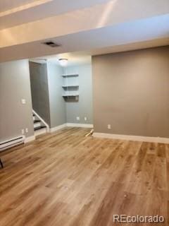 6973 Summerset Ave, Longmont, CO 80504 - finished below grade area featuring wood finished floors, baseboards, stairs, and a baseboard heating unit