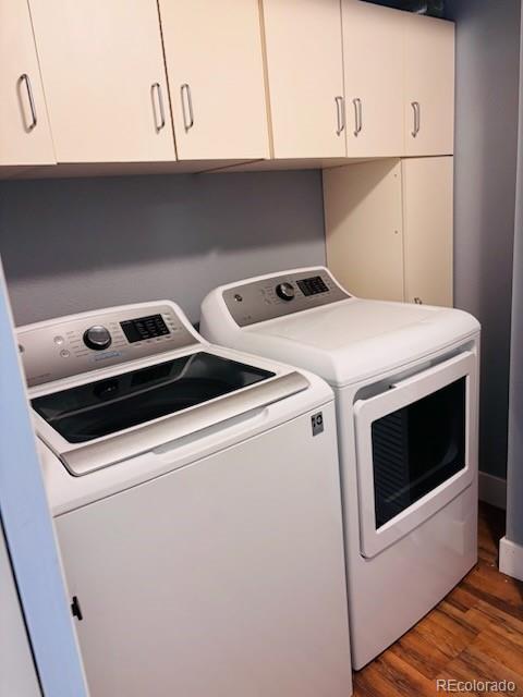 6973 Summerset Ave, Longmont, CO 80504 - laundry area featuring washer and clothes dryer, cabinet space, and wood finished floors