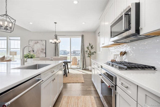 15608 E Otero Cir, Centennial, CO 80112 - kitchen featuring stainless steel appliances, a chandelier, a sink, light countertops, and recessed lighting
