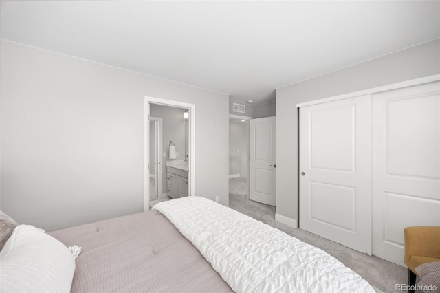 15608 E Otero Cir, Centennial, CO 80112 - bedroom with light carpet, a closet, ensuite bathroom, and baseboards