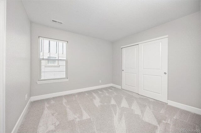 15608 E Otero Cir, Centennial, CO 80112 - unfurnished bedroom with baseboards, light colored carpet, and a closet