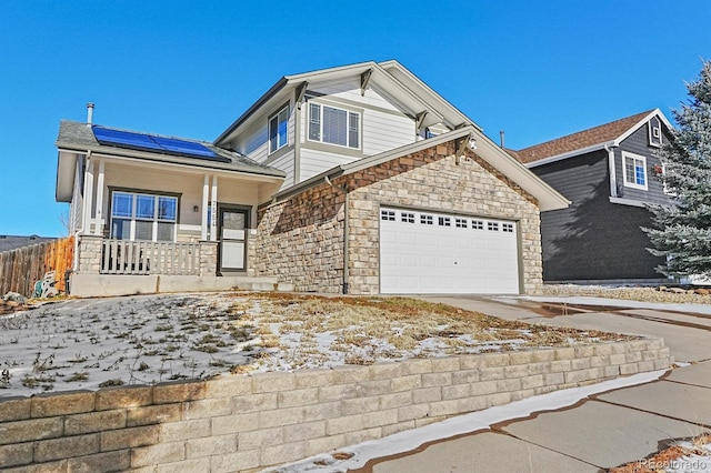 view of front of property with solar panels, a porch, and a garage