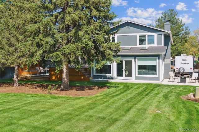 6537 S Brentwood Way, Littleton, CO 80123 - back of property with a chimney, a lawn, french doors, and a patio area