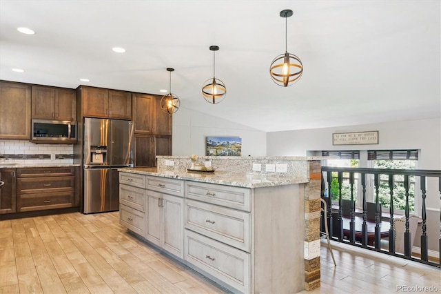 6537 S Brentwood Way, Littleton, CO 80123 - kitchen featuring appliances with stainless steel finishes, light wood-style flooring, a center island, backsplash, and vaulted ceiling