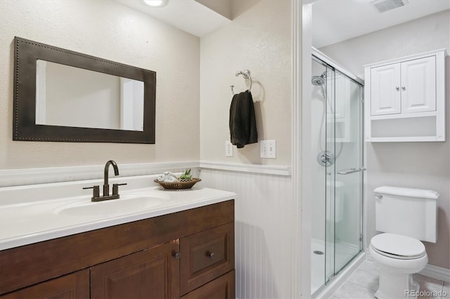 6537 S Brentwood Way, Littleton, CO 80123 - full bathroom with vanity, a stall shower, toilet, a wainscoted wall, and tile patterned flooring