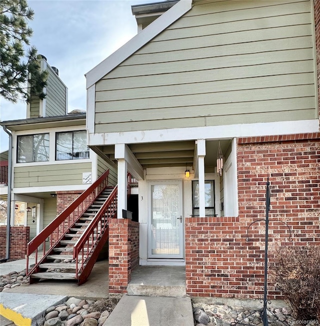 view of exterior entry featuring brick siding