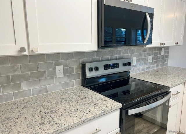 kitchen featuring white cabinets, tasteful backsplash, light stone counters, and stainless steel appliances