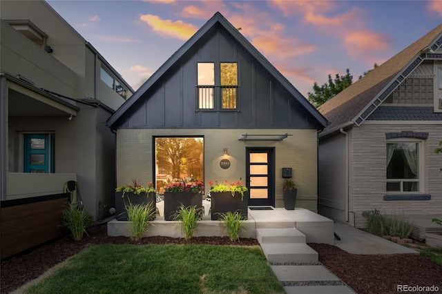 3363 W 32nd Ave, Denver, CO 80211 - view of front facade featuring board and batten siding, brick siding, and a front yard