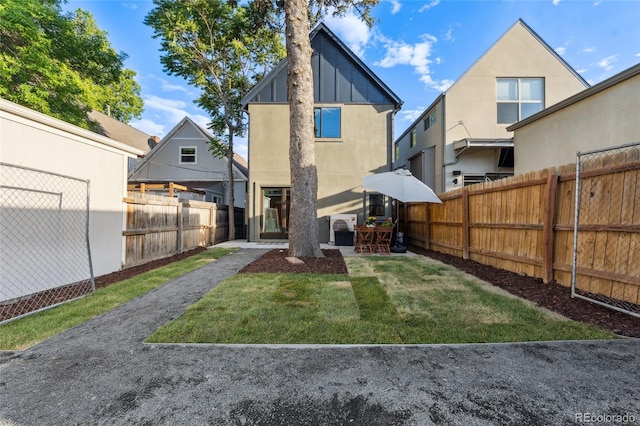 3363 W 32nd Ave, Denver, CO 80211 - rear view of house with board and batten siding, a fenced backyard, and a patio area
