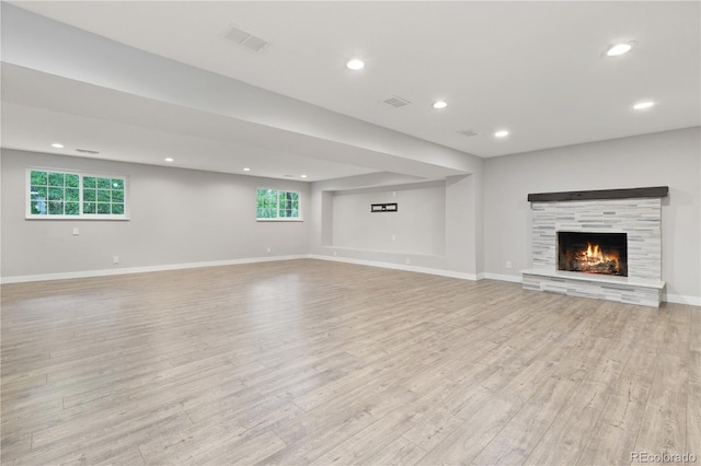 6451 S Hoyt St, Littleton, CO 80123 - unfurnished living room with light wood-type flooring, a lit fireplace, and recessed lighting