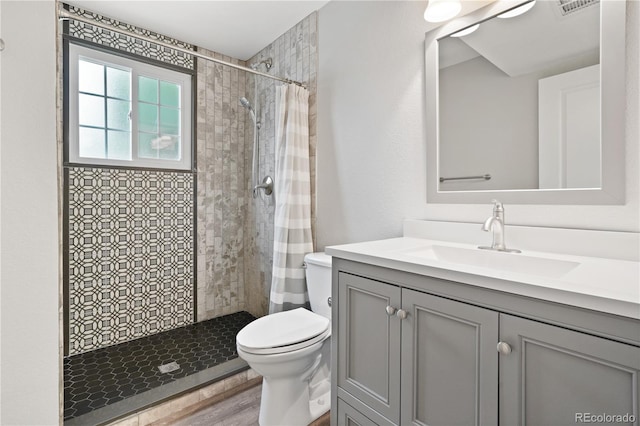 6451 S Hoyt St, Littleton, CO 80123 - full bathroom featuring vanity, a tile shower, and wood finished floors