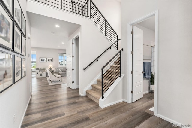 interior space with baseboards, recessed lighting, wood finished floors, and stairway