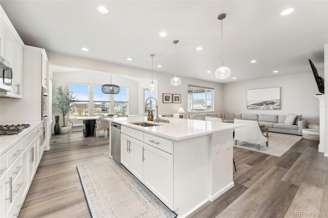 kitchen featuring recessed lighting, a sink, white cabinets, and stainless steel appliances