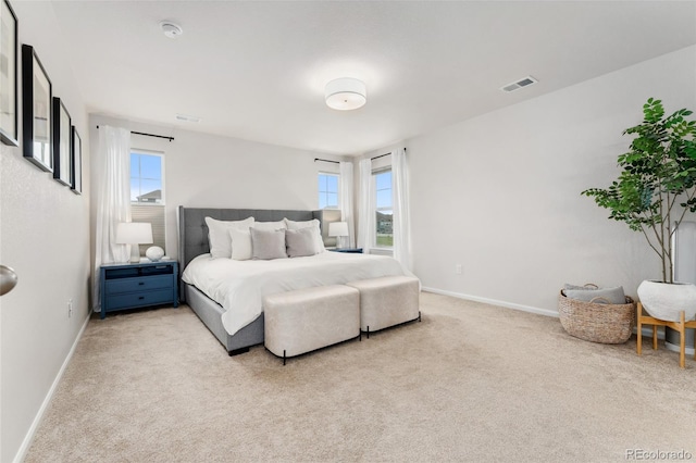 bedroom featuring baseboards, visible vents, and light carpet
