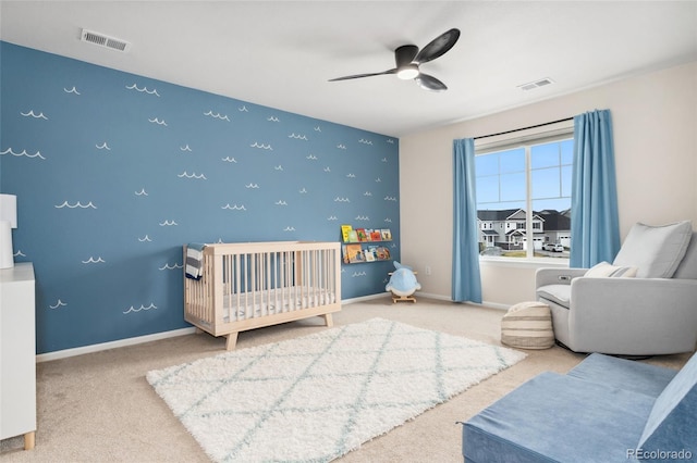 carpeted bedroom with visible vents, baseboards, and an accent wall
