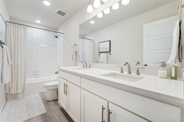 bathroom with visible vents, a sink, wood finished floors, and toilet