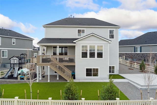 back of house featuring a lawn, a playground, fence private yard, and a patio area