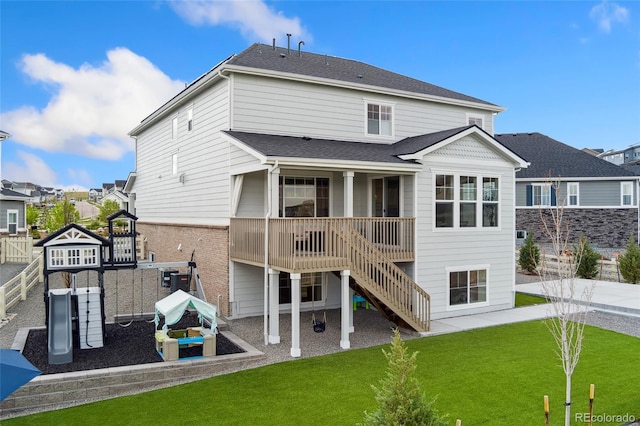 back of house with a yard, stairs, and a playground