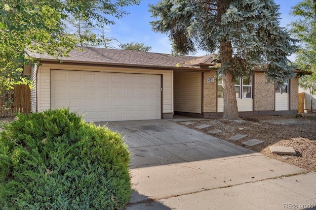 single story home with driveway and an attached garage