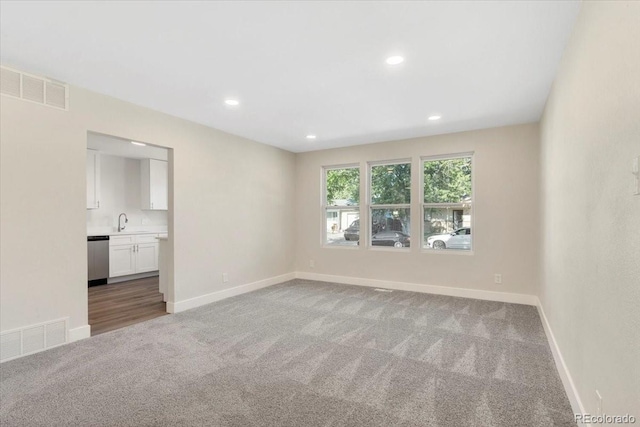 unfurnished bedroom featuring a sink, visible vents, baseboards, and carpet