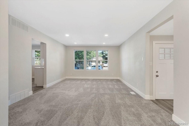 carpeted spare room featuring recessed lighting, baseboards, and visible vents