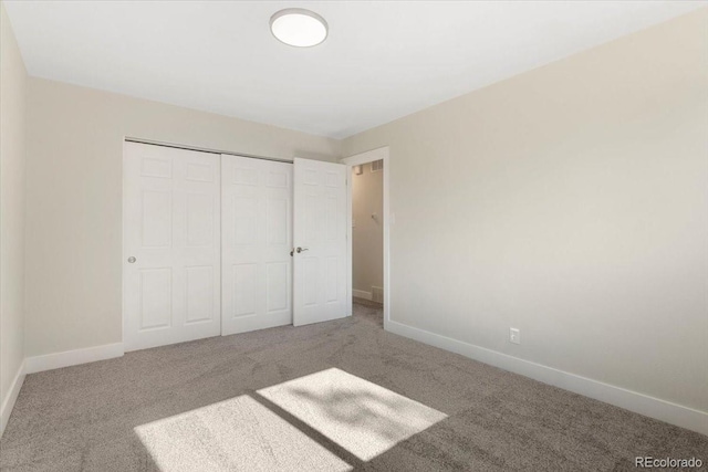 unfurnished bedroom featuring a closet, baseboards, and carpet