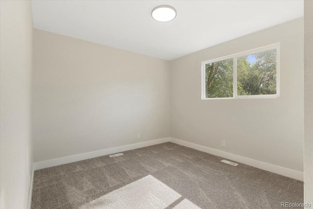 carpeted empty room with visible vents and baseboards