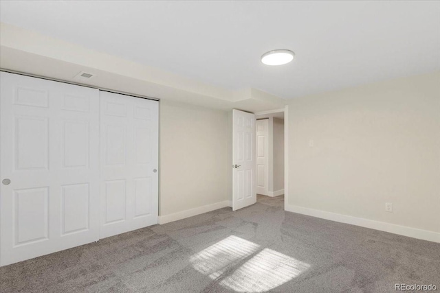 unfurnished bedroom with baseboards, carpet floors, and a closet