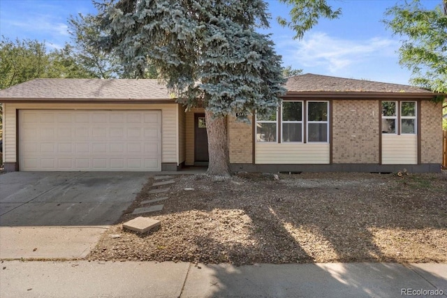 ranch-style home featuring brick siding, an attached garage, and driveway