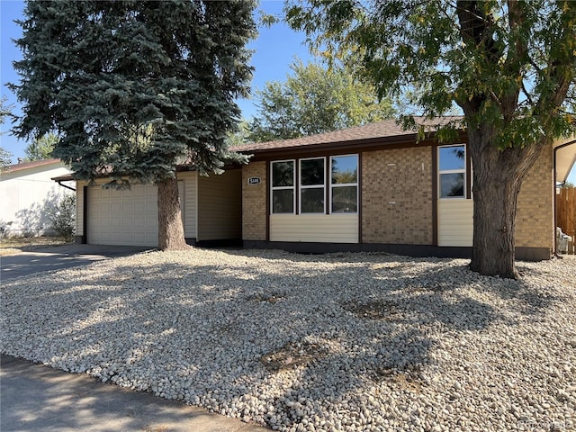 ranch-style home with a garage, brick siding, and driveway