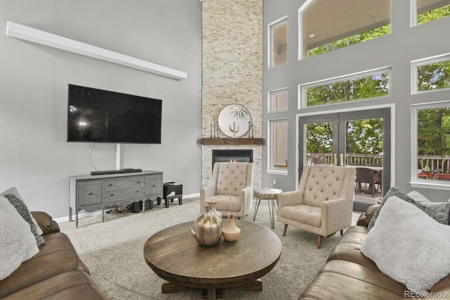 carpeted living room featuring a towering ceiling and a wealth of natural light